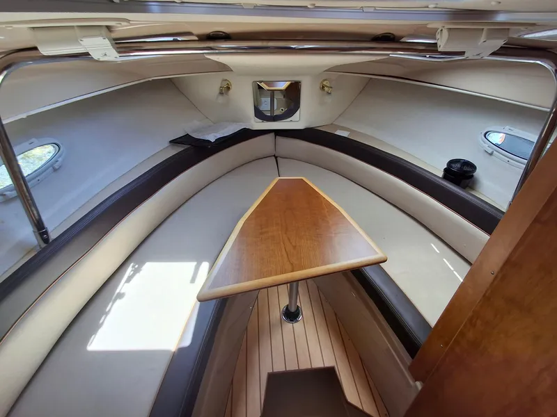 Slide: The Image of Interior of a 2017 Cutwater C24 boat with a wooden table and cushioned seating. - 17