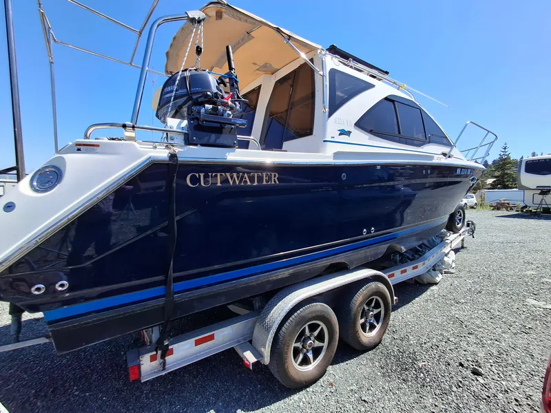 Slide: The Image of 2017 Cutwater C24 boat on trailer, blue hull, outdoor setting. - 2
