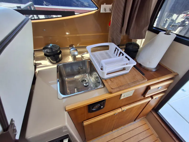 Slide: The Image of Compact kitchen area in a 2017 Cutwater C24 boat with sink and storage. - 22