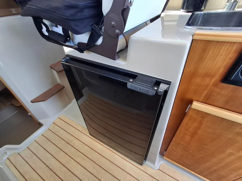Slide: The Image of Cutwater C24 2017 boat interior with Nova Kool fridge and wooden cabinetry. - 26