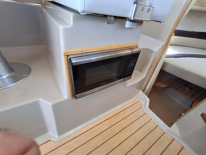 Slide: The Image of 2017 Cutwater C24 interior with built-in microwave and wooden flooring. - 27