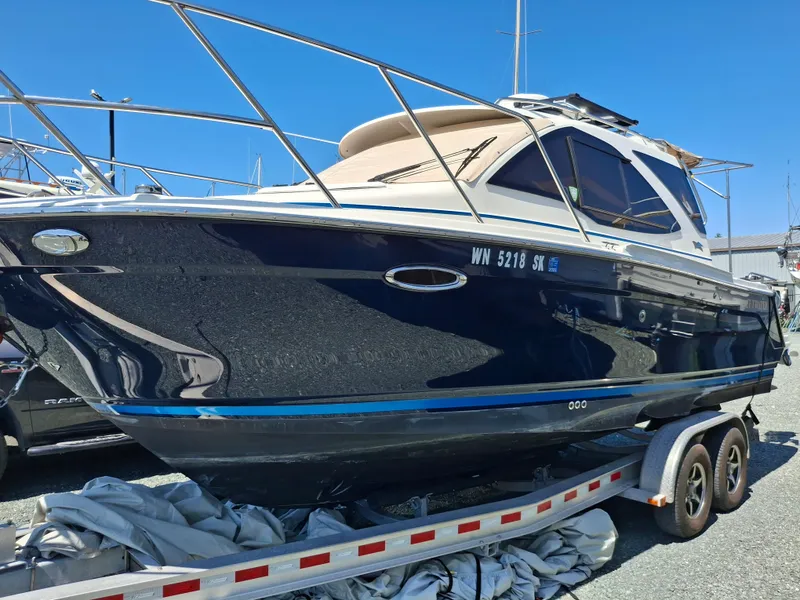 Slide: The Image of 2017 Cutwater C24 boat on trailer, dark blue hull, sunny day. - 3