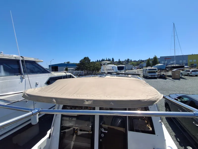 Slide: The Image of 2017 Cutwater C24 boat with canopy, parked in a marina under clear blue sky. - 34