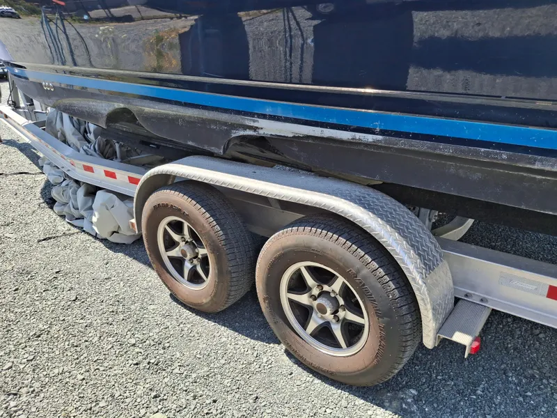 Slide: The Image of 2017 Cutwater C24 boat on trailer with dual wheels, parked on gravel. - 35