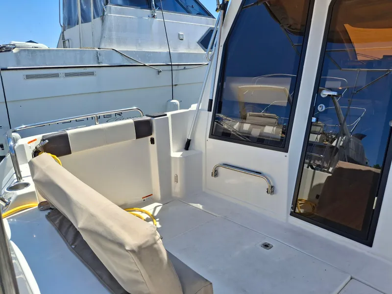 Slide: The Image of 2017 Cutwater C24 boat deck with seating and glass doors, docked beside another vessel. - 6