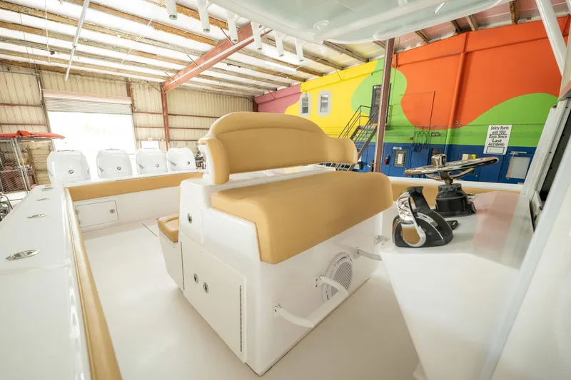 Slide: The Image of 2020 Bahama 41 Open Fisherman boat interior with tan seating in a colorful warehouse. - 5