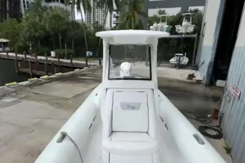 Slide: The Image of 2023 Airship 310-Rib boat with open storage compartment in a marina setting. - 14