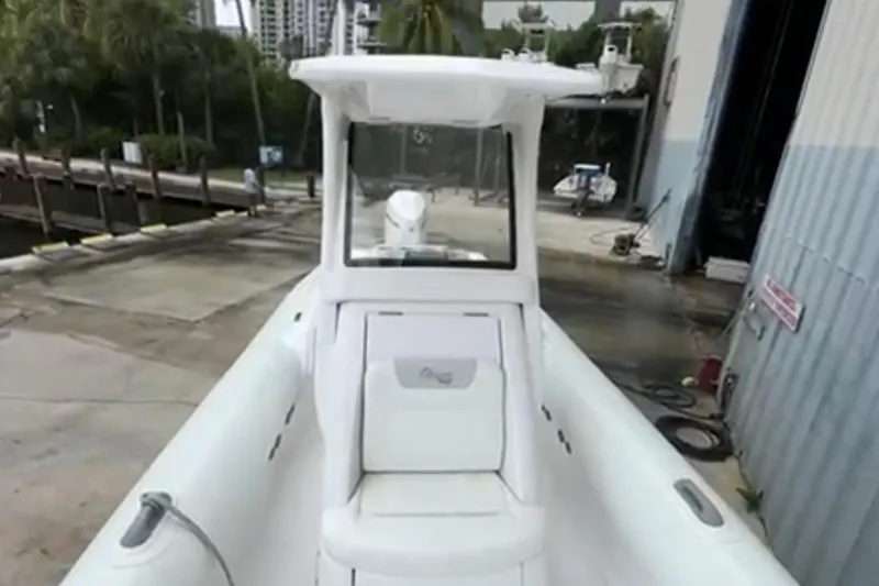 Slide: The Image of 2023 Airship 310-Rib boat docked, featuring sleek white design and spacious seating. - 15