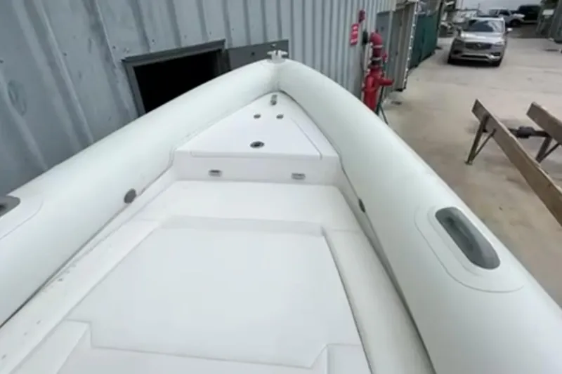 Slide: The Image of 2023 Airship 310-Rib boat interior with steering wheel, dockside view, and waterfront buildings. - 16