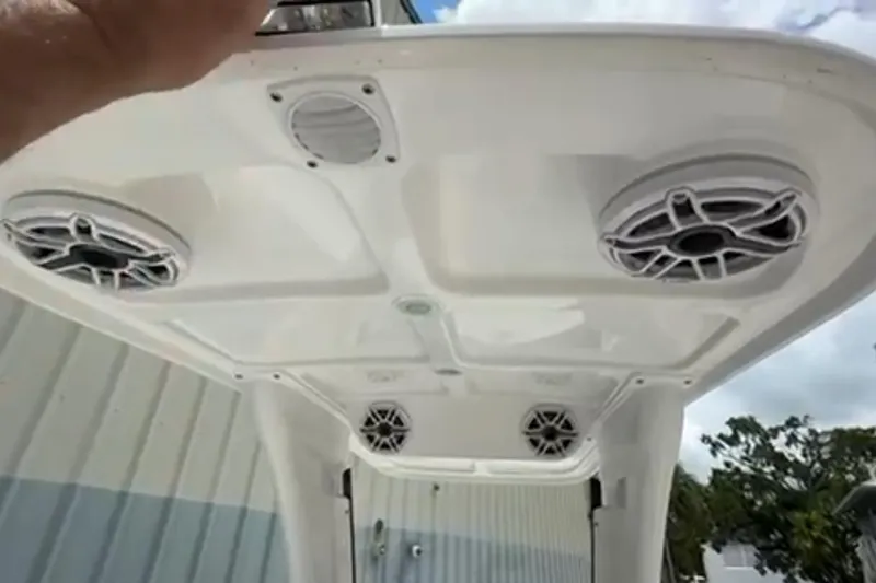 Slide: The Image of Interior view of 2023 Airship 310-Rib boat with white seating near a building. - 20