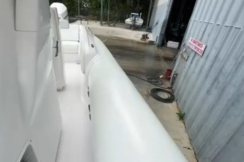 Slide: The Image of 2023 Airship 310-Rib boat docked near waterfront buildings with palm trees. - 23