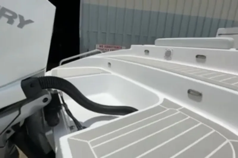 Slide: The Image of 2023 Airship 310-Rib boat with Mercury outboard motor, docked near a metal building. - 6