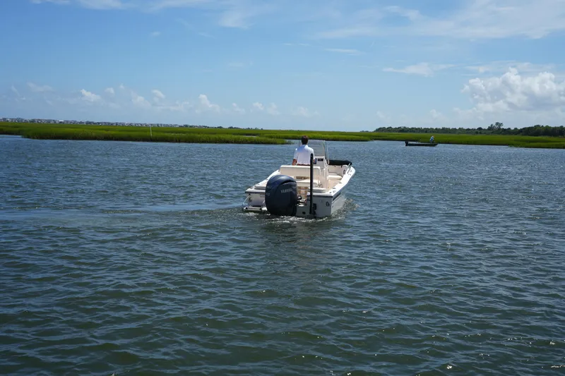 Slide: The Image of 2024 Grady-White Fisherman 180 boat cruising on a calm lake under a clear blue sky. - 12