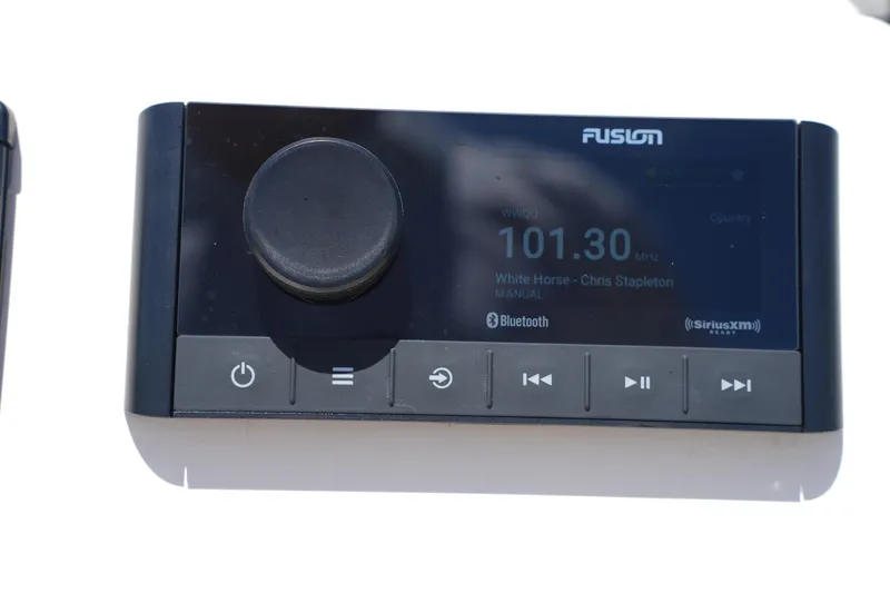 Slide: The Image of Fusion marine stereo system on 2024 Grady-White Fisherman 180 boat, displaying radio station and song. - 21