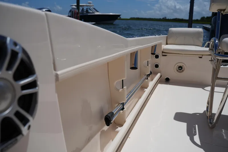 Slide: The Image of 2024 Grady-White Fisherman 180 boat interior with seating and rod holders, docked by water. - 24