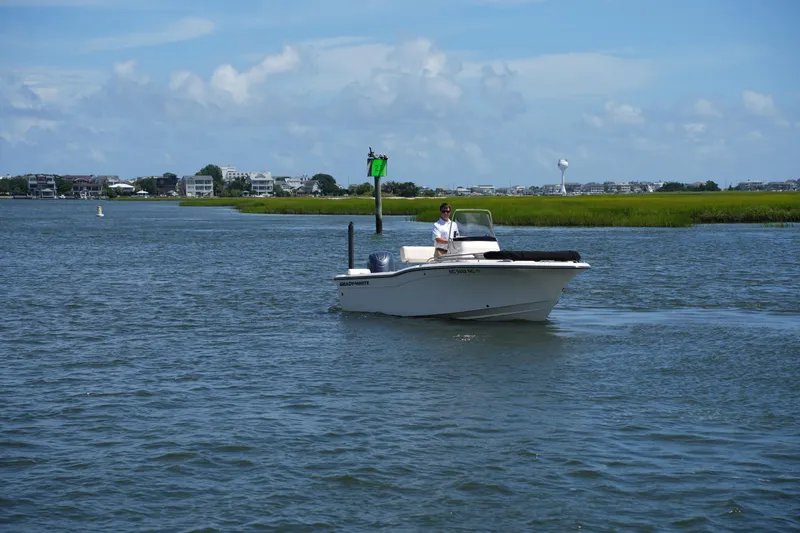 Slide: The Image of 2024 Grady-White Fisherman 180 boat cruising on a scenic waterway under a clear blue sky. - 5