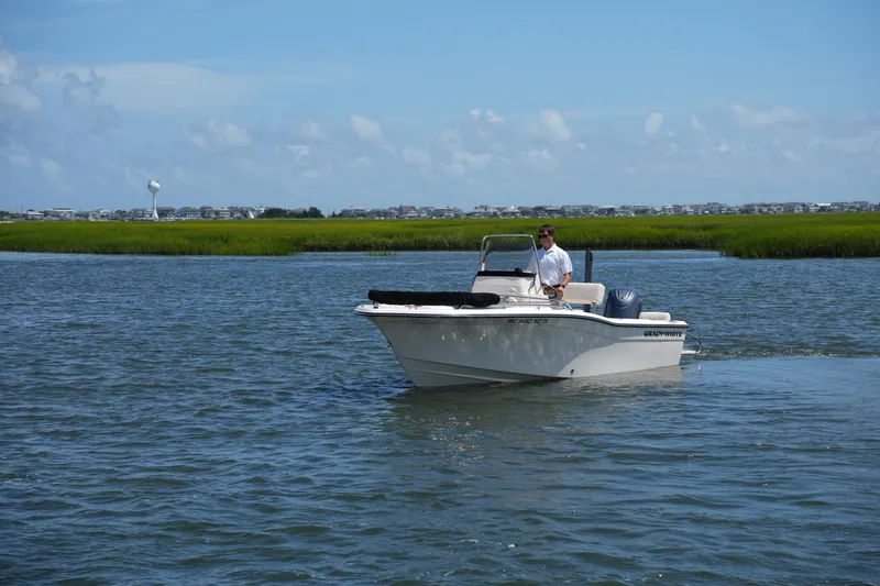Slide: The Image of 2024 Grady-White Fisherman 180 boat cruising on a calm waterway under a clear blue sky. - 8