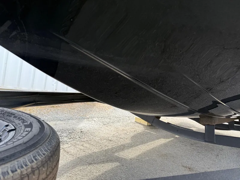 Slide: The Image of 2021 Skeeter ZX 150 boat hull and trailer tire on gravel surface. - 18