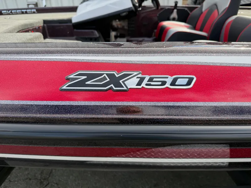 Slide: The Image of 2021 Skeeter ZX 150 boat with red and black detailing, interior seats visible. - 2