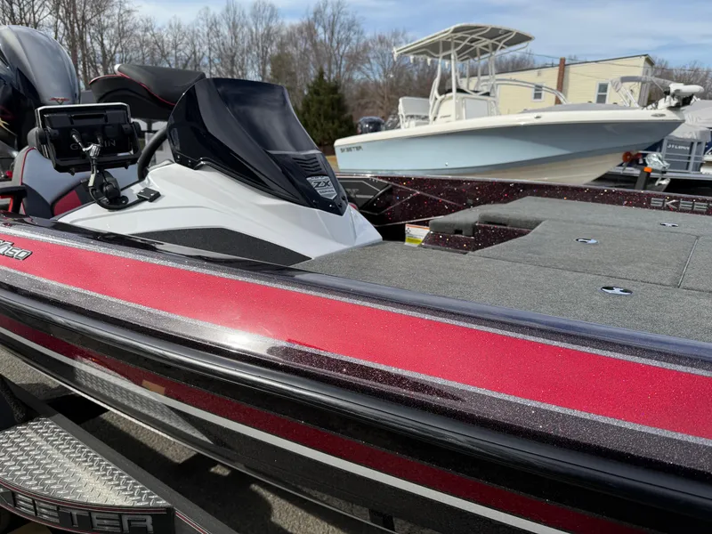 Slide: The Image of 2021 Skeeter ZX 150 boat with red accents, parked outdoors. - 6