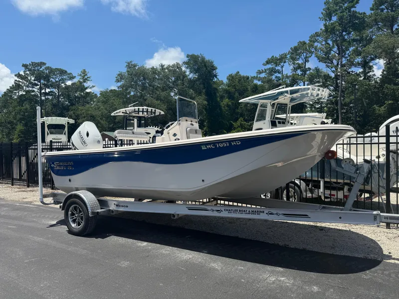 Slide: The Image of 2025 Carolina Skiff 19 LS boat on trailer, parked outdoors under blue sky. - 1
