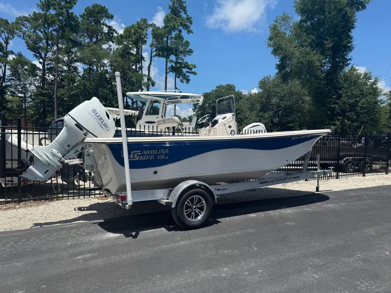 Slide: The Image of 2025 Carolina Skiff 19 LS boat on trailer, parked outdoors under clear sky. - 2