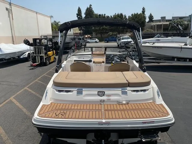 Slide: The Image of 2022 Bayliner VR4 Bowrider I/O boat with tan seating and swim platform in a marina. - 14