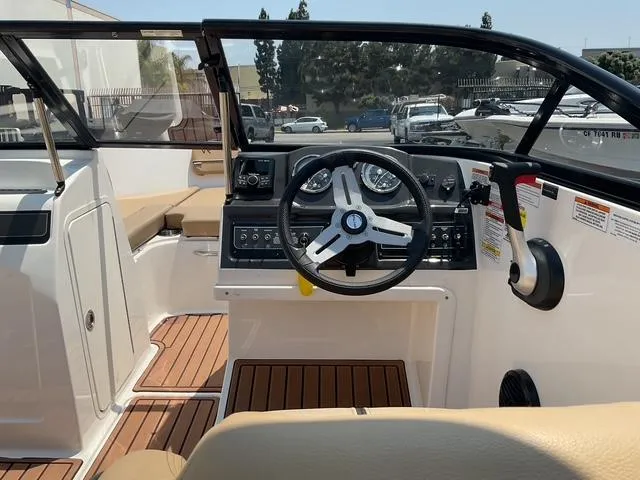Slide: The Image of 2022 Bayliner VR4 Bowrider I/O interior with steering wheel and dashboard, featuring wood accents. - 9