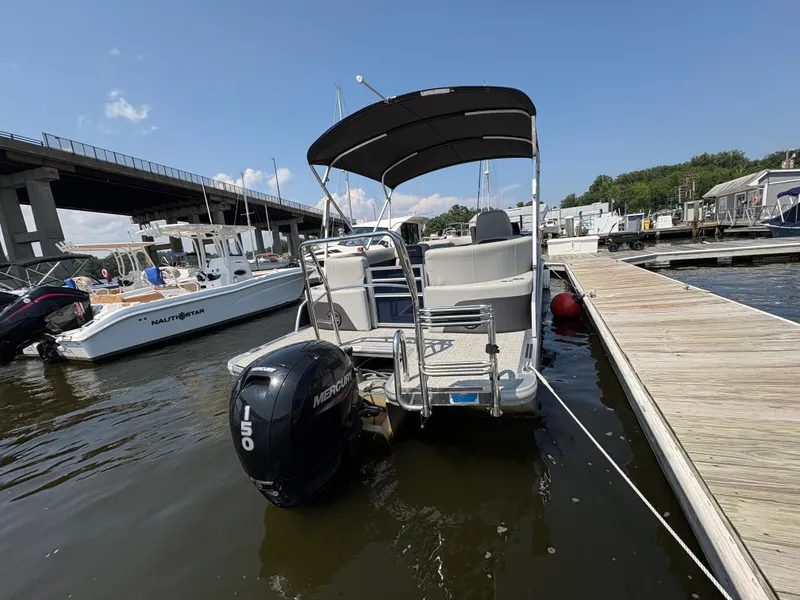 Slide: The Image of 2024 Harris Cruiser 230 pontoon boat docked with Mercury 150 engine. - 5