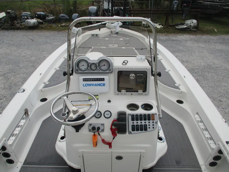 Slide: The Image of 2015 NauticStar 224 boat dashboard with steering wheel, gauges, and controls. - 2