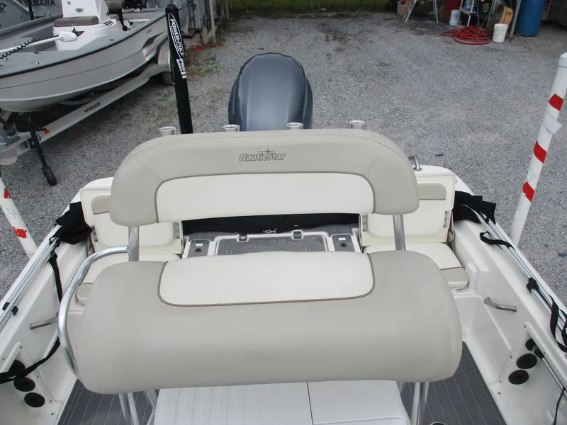 Slide: The Image of 2015 NauticStar 224 boat interior with beige seating and engine view. - 6