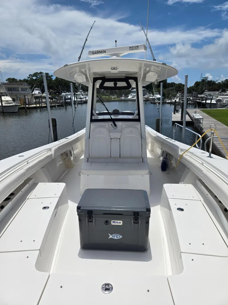 Slide: The Image of 2023 Regulator 34 boat docked, featuring spacious deck and Garmin equipment under a clear sky. - 18