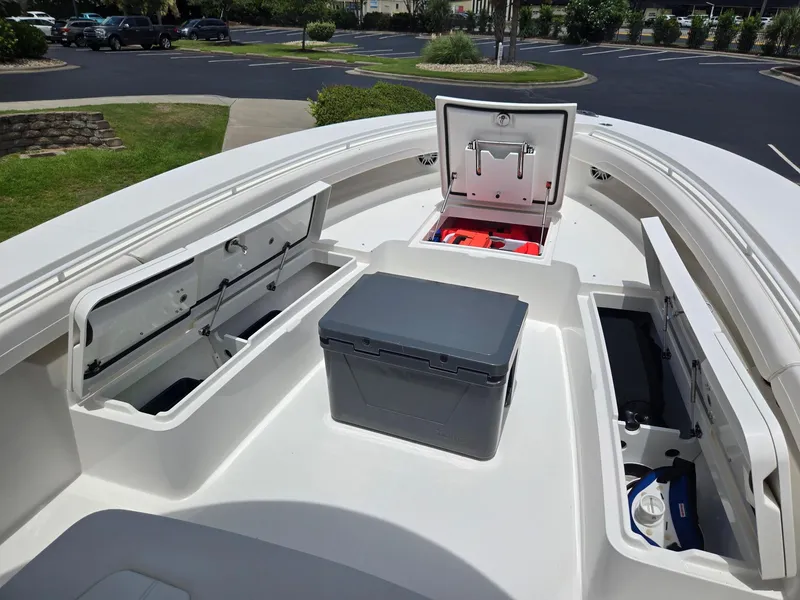 Slide: The Image of 2023 Regulator 34 boat interior with open storage compartments and cooler. - 19