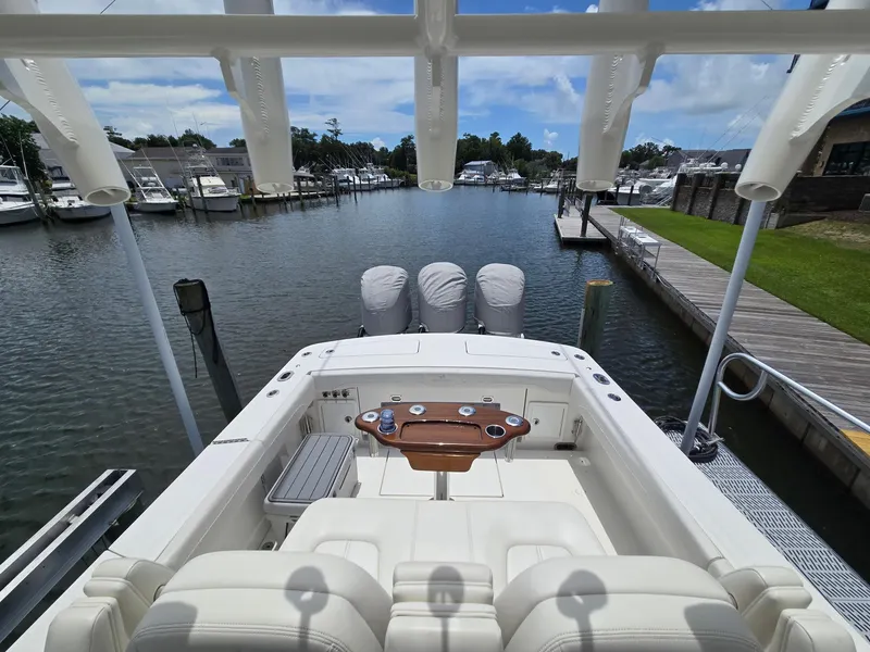 Slide: The Image of 2023 Regulator 34 boat docked, featuring triple engines and spacious seating area. - 23