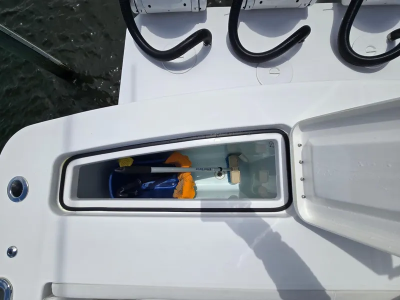 Slide: The Image of 2023 Regulator 34 boat storage compartment with cleaning tools and accessories. - 28