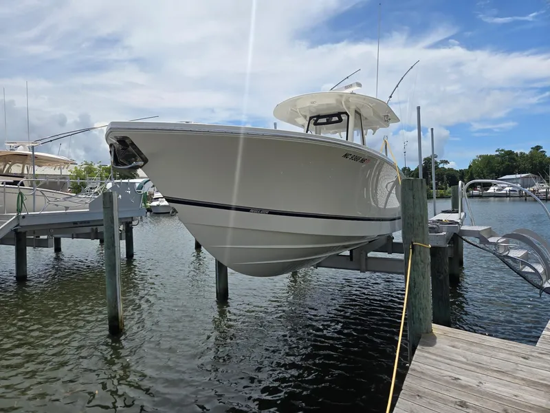 Slide: The Image of 2023 Regulator 34 boat docked on a lift, under a clear blue sky. - 4