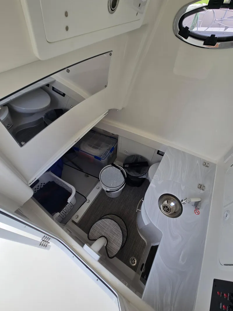 Slide: The Image of 2023 Regulator 34 boat interior with compact bathroom and storage area. - 9