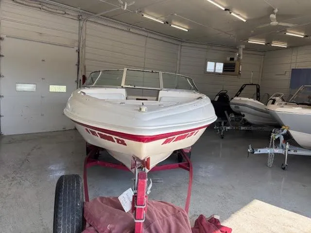 Slide: The Image of 2000 Rinker Captiva 212 boat in a garage, front view on a trailer. - 10