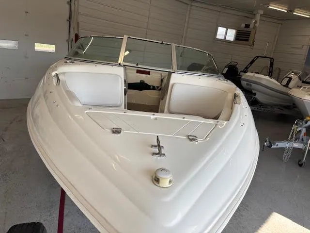 Slide: The Image of 2000 Rinker Captiva 212 boat in a garage, showcasing its sleek white design. - 11