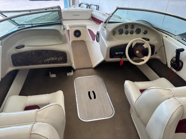 Slide: The Image of 2000 Rinker Captiva 212 boat interior with beige seating and dashboard controls. - 21