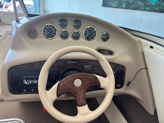 Slide: The Image of Dashboard of a 2000 Rinker Captiva 212 boat with steering wheel and gauges. - 25