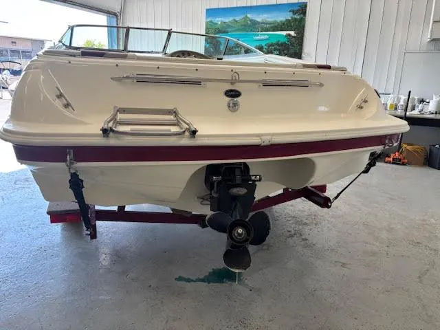 Slide: The Image of 2000 Rinker Captiva 212 boat in a garage, rear view showing propeller and ladder. - 3