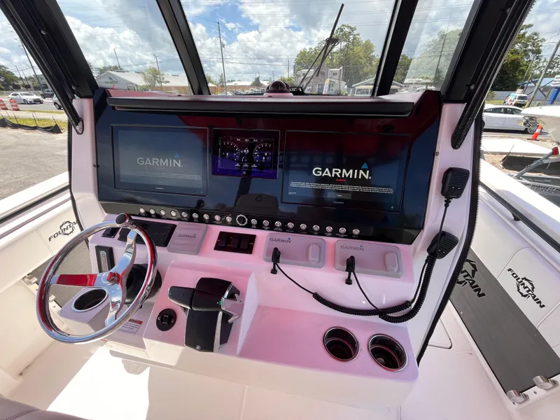 Slide: The Image of 2023 Fountain 38 Tournament Edition boat dashboard with Garmin navigation system and steering wheel. - 11