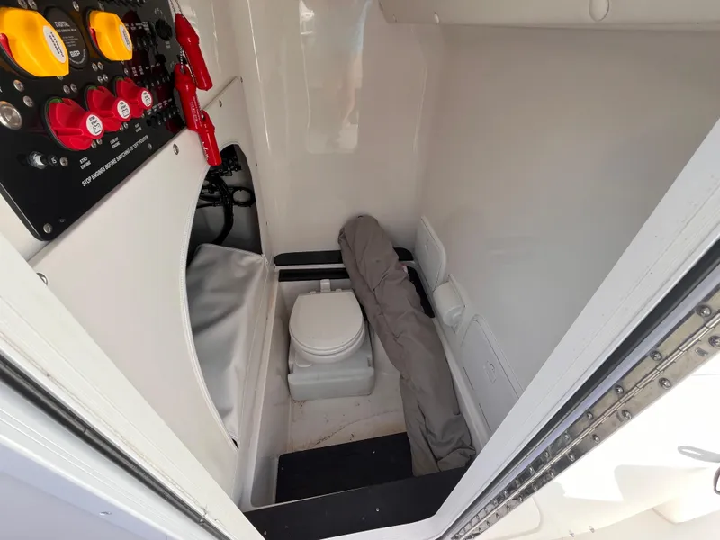 Slide: The Image of 2023 Fountain 38 Tournament Edition boat interior with control panel and compact toilet. - 13