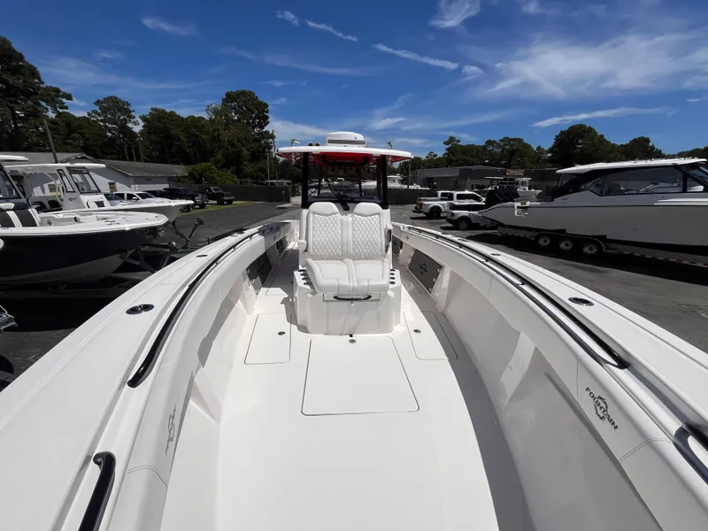 Slide: The Image of 2023 Fountain 38 Tournament Edition boat, sleek design, spacious deck, parked outdoors under blue sky. - 15