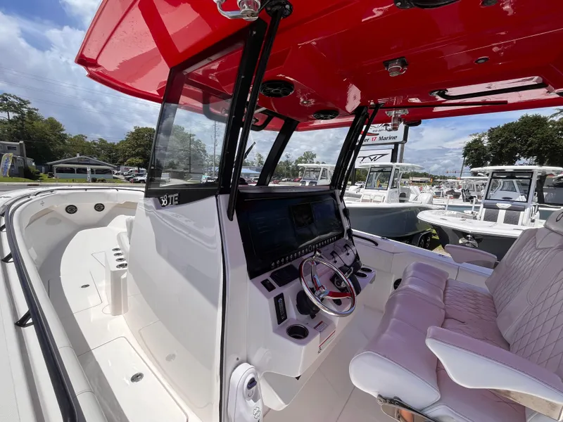 Slide: The Image of 2023 Fountain 38 Tournament Edition boat interior with red canopy and modern dashboard. - 19