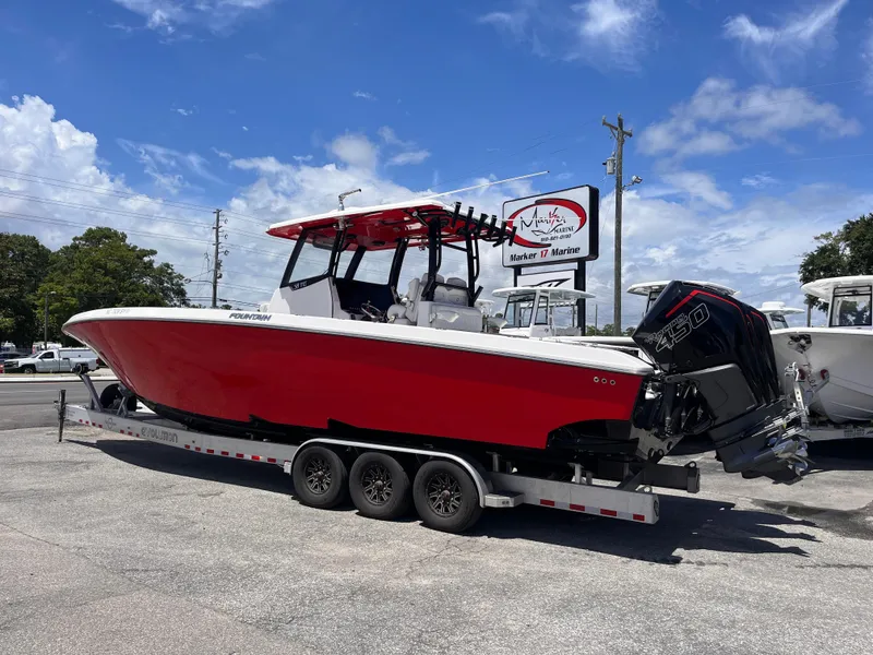Slide: The Image of 2023 Fountain 38 Tournament Edition boat with red hull on a trailer, parked outdoors. - 3