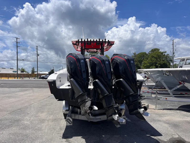 Slide: The Image of 2023 Fountain 38 Tournament Edition boat with triple outboard engines, parked under a cloudy sky. - 4