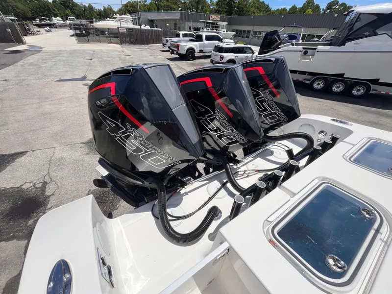 Slide: The Image of Triple outboard engines on a 2023 Fountain 38 Tournament Edition boat, parked in a marina. - 6