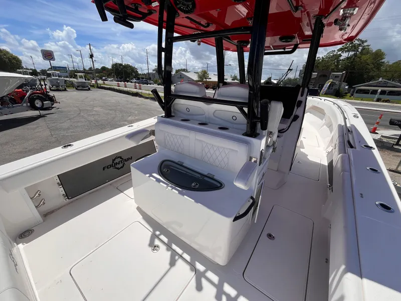 Slide: The Image of 2023 Fountain 38 Tournament Edition boat interior with seating and storage, parked outdoors. - 8